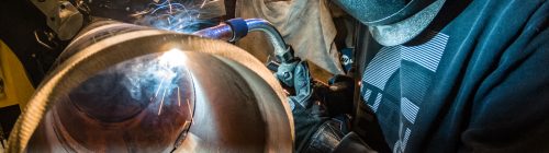 Welder repairing a metal duct component
